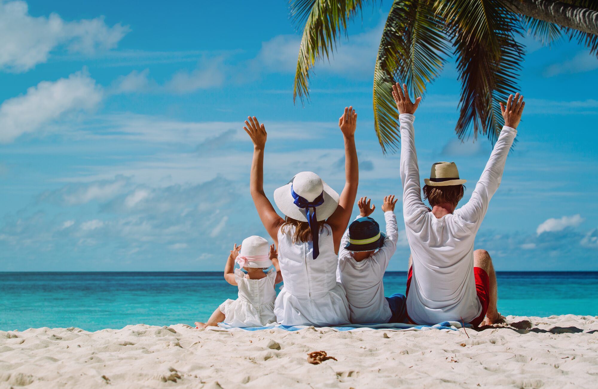 Familia sentada en una playa paradisíaca